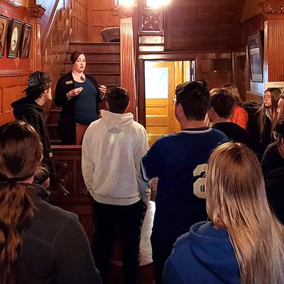 a groups listens to a tour guide inside the frank museum